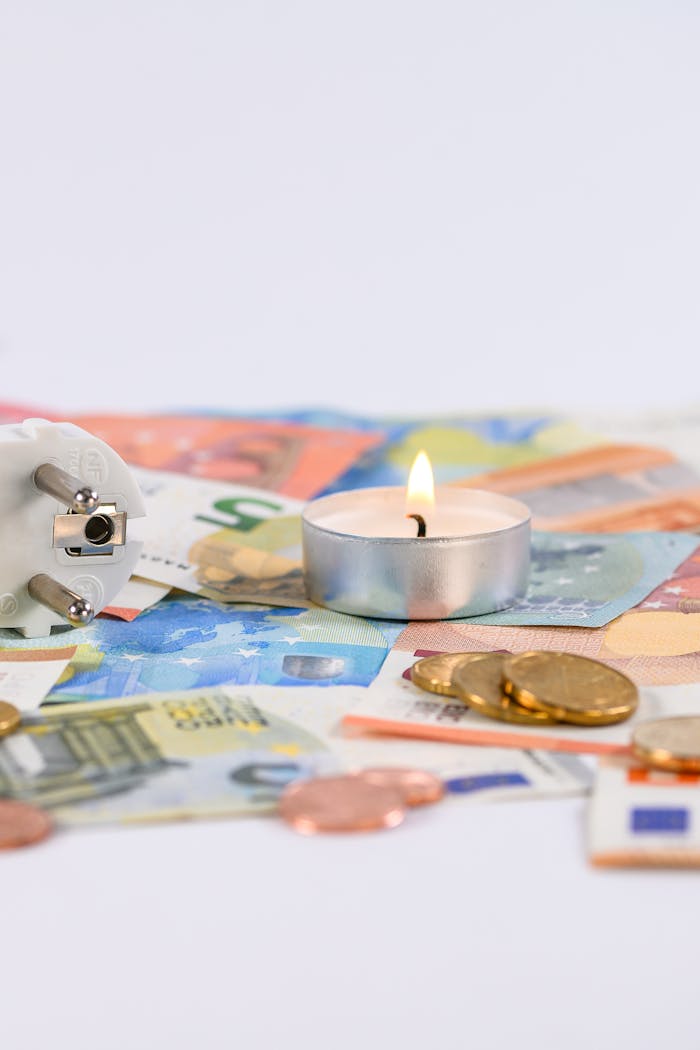 services-10 A burning candle on Euro money with a power plug symbolizing energy costs.